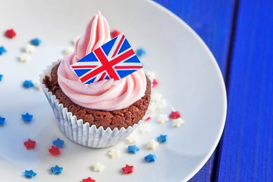 Schokoladen-Cupcake mit rosa Sahencreme und mit englischem Fähnchen