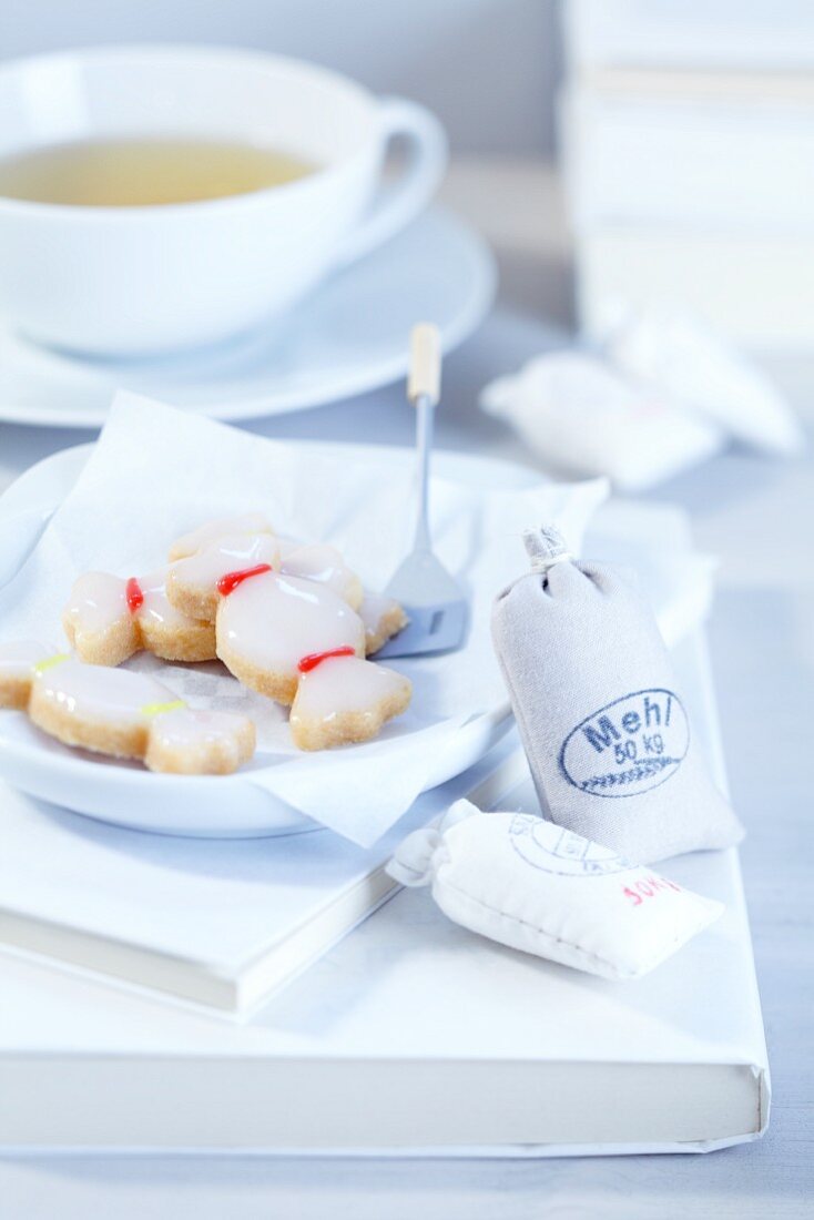Bonbonförmige Mürbeteigkekse mit Zuckerglasur und Mini-Mehlsäcke