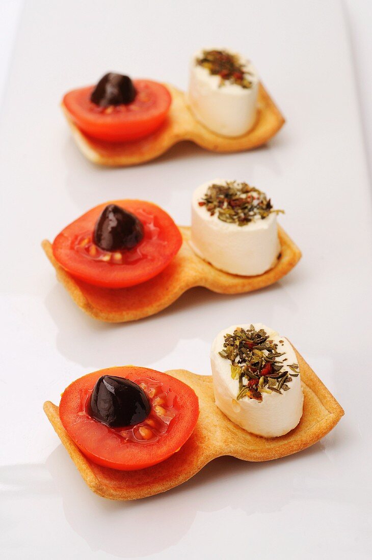 Canapés mit Frischkäse, Tomaten und Oliven