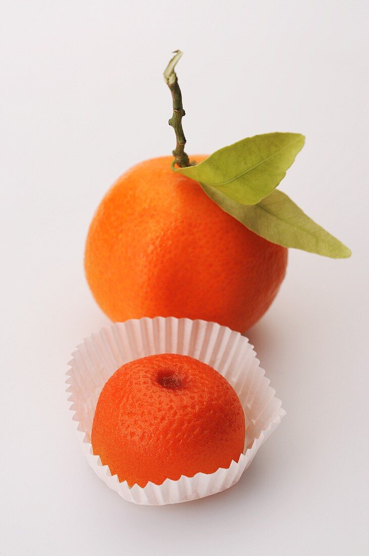 A fresh clementine and a marzipan clementine