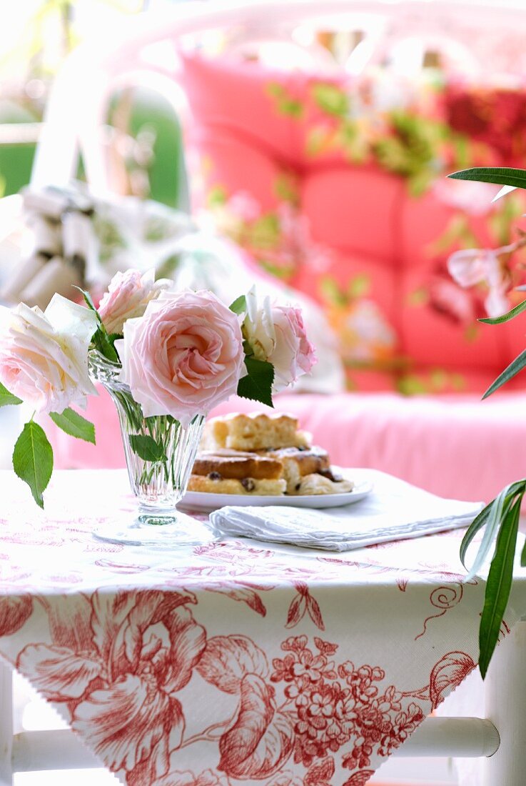 Roses and cakes on small bamboo table