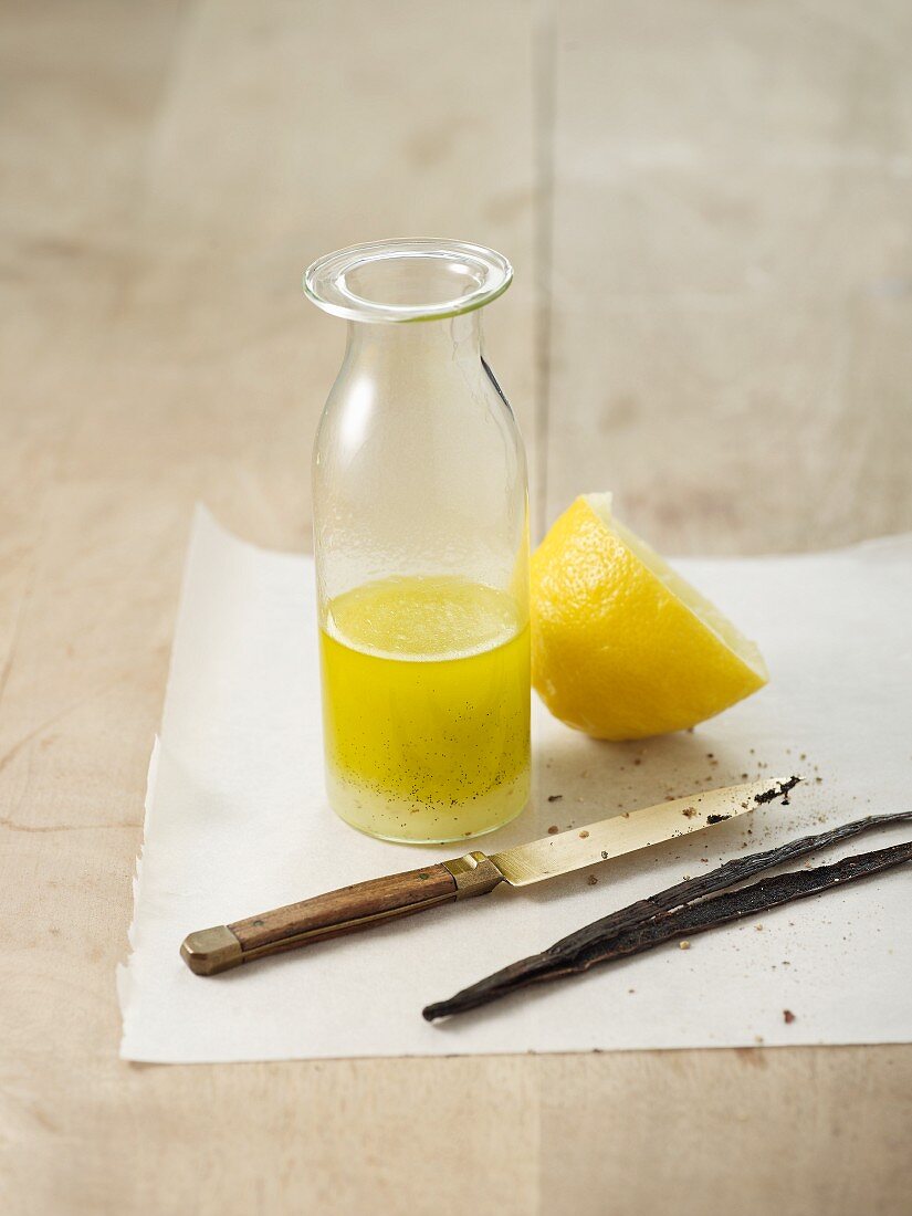 Lemon juice with sugar and fresh vanilla in a glass bottle