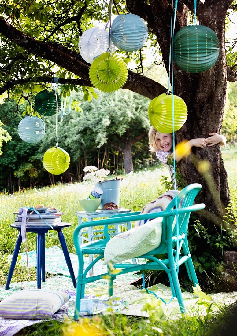 Patterned lanterns hanging from tree in garden