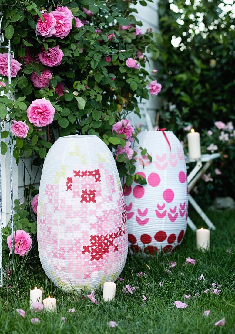 Large paper lanterns with embroidery-style patterns in garden