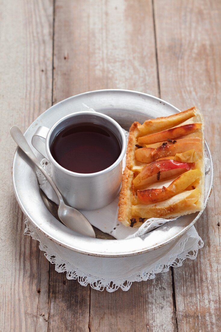 A slice of apple and cinnamon tart and a cup of tea