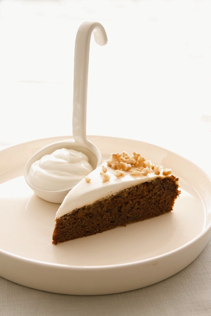 A slice of chocolate and almond cake topped with cream cheese