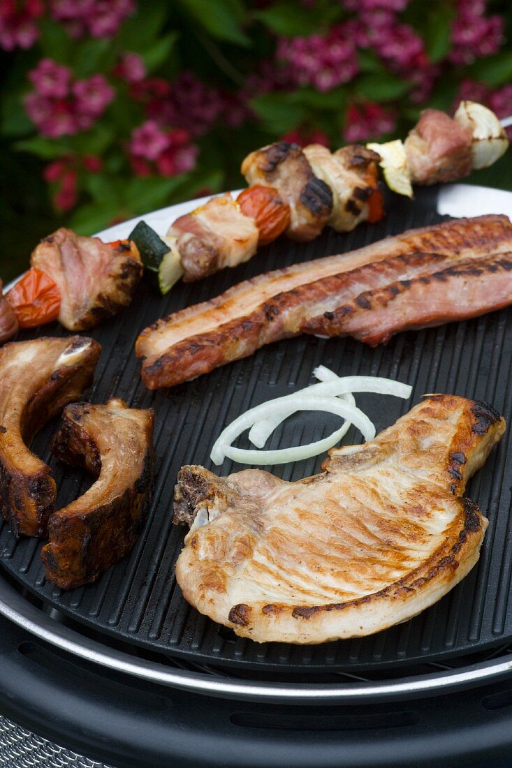 A pork chop, a kebab and a rib on a barbecue