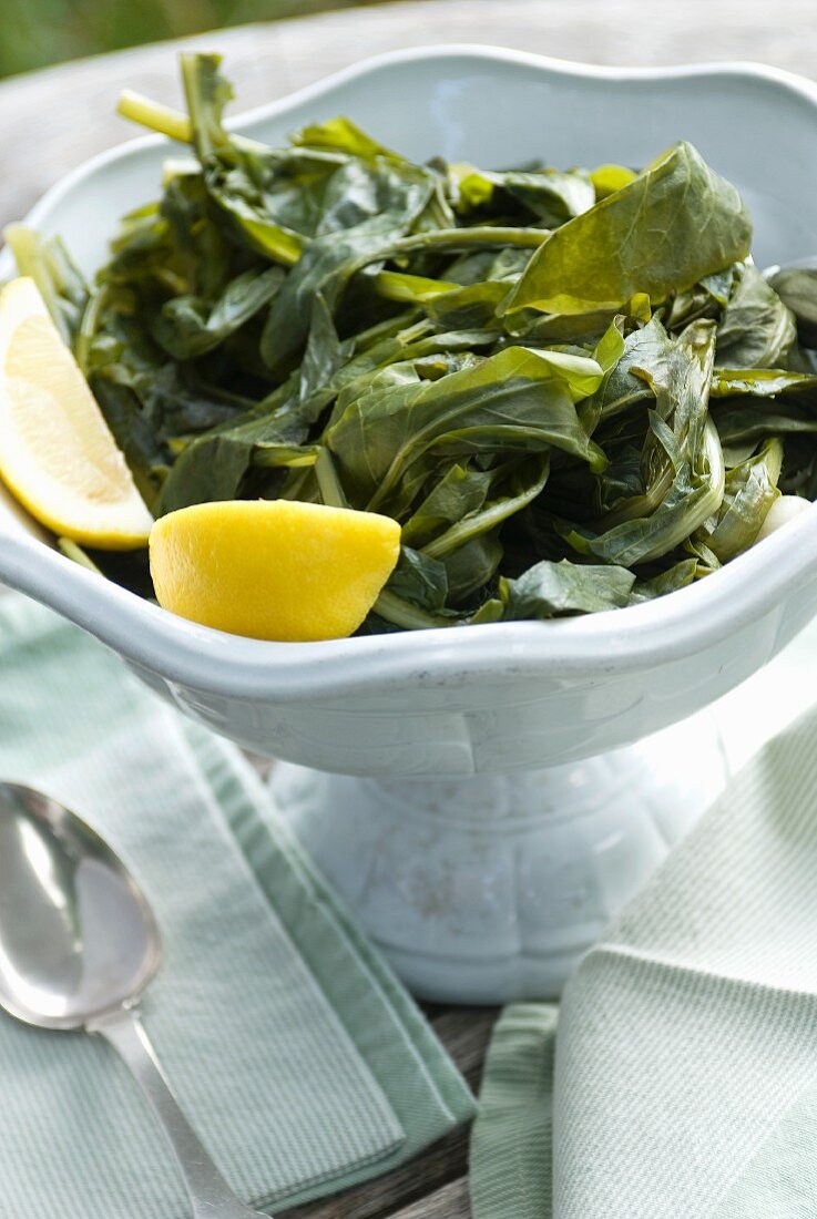 Steamed Greens (Horta) in a Bowl with Lemon Wedges