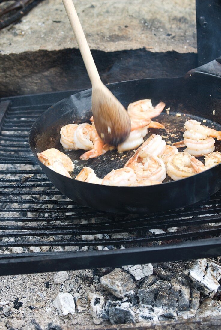 Cooking Shrimp in a Cast Iron Pan Over an Outdoor Fire