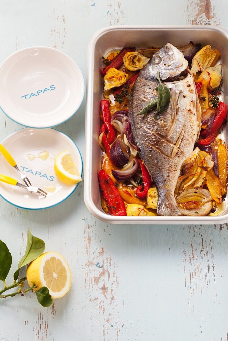 Trout filled with sage on a bed of oven-roasted vegetables