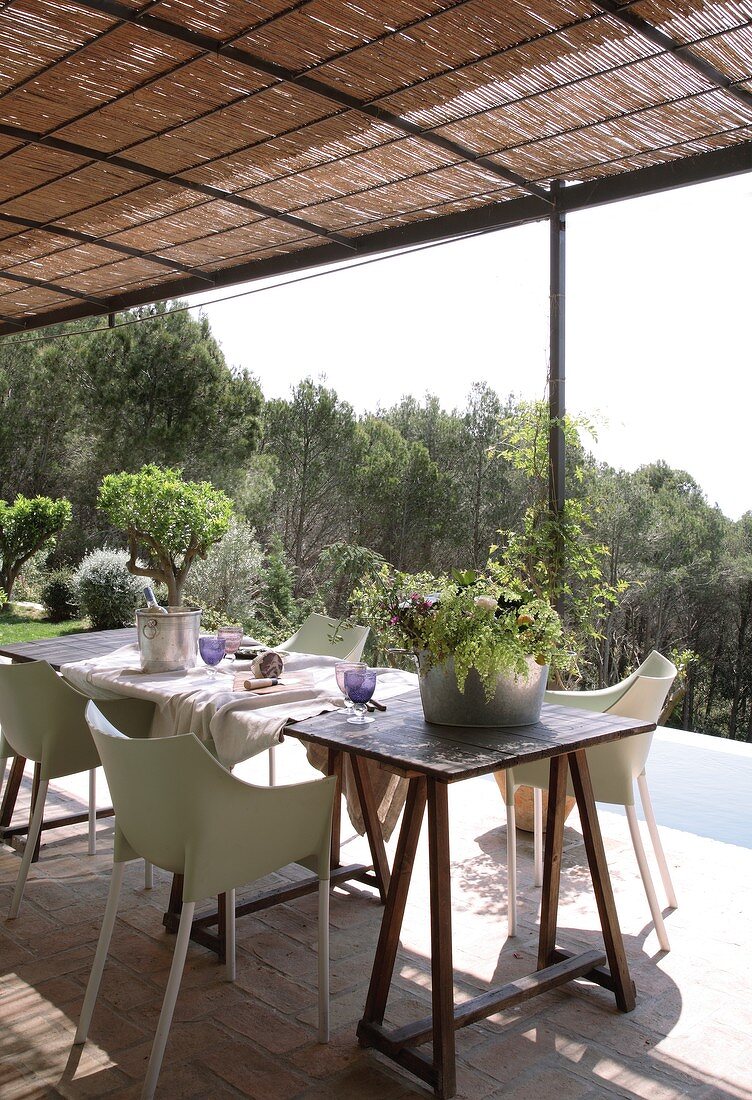 Dining area on roofed terrace with bamboo mat pergola