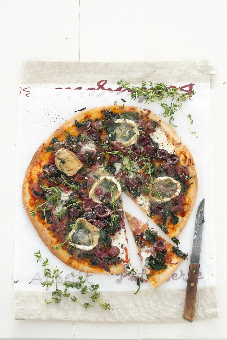 Red onion, spinach, goat's cheese and olive pizza