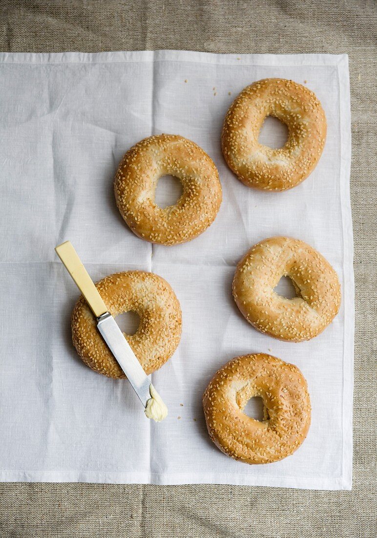Five sesame seed bagels and a butter knife