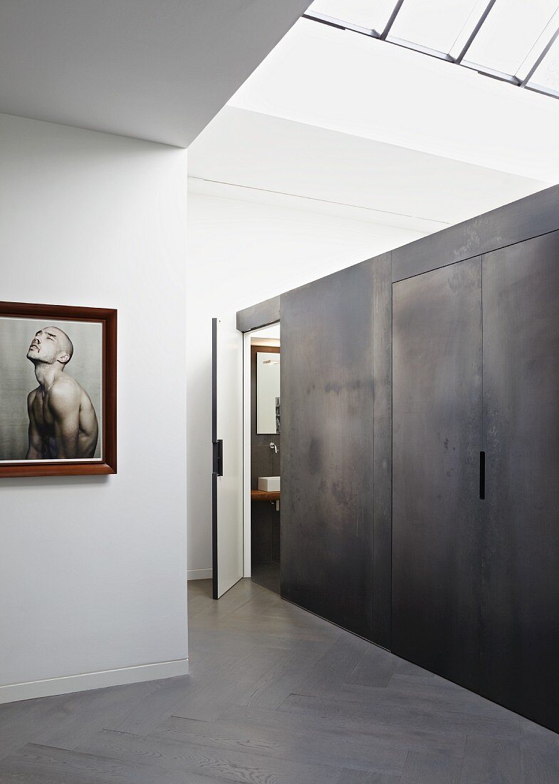 Einbau mit Metall-Look an Wand in minimalistischem Wohnraum mit Oberlicht