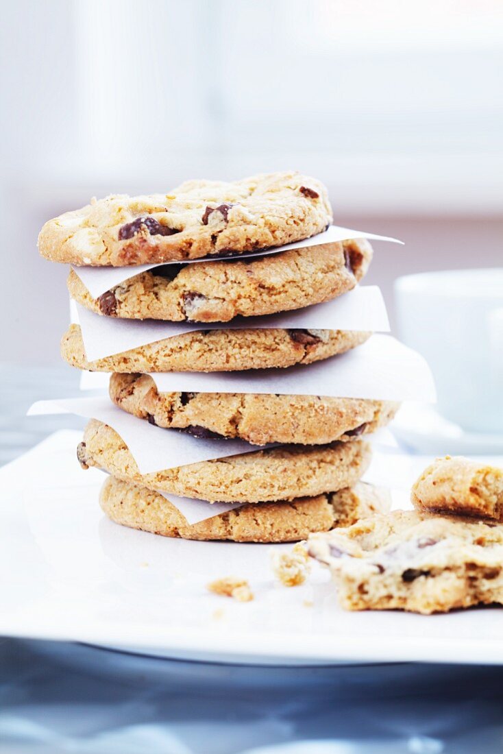 A stack of chocolate and nut cookies between sheets of baking paper