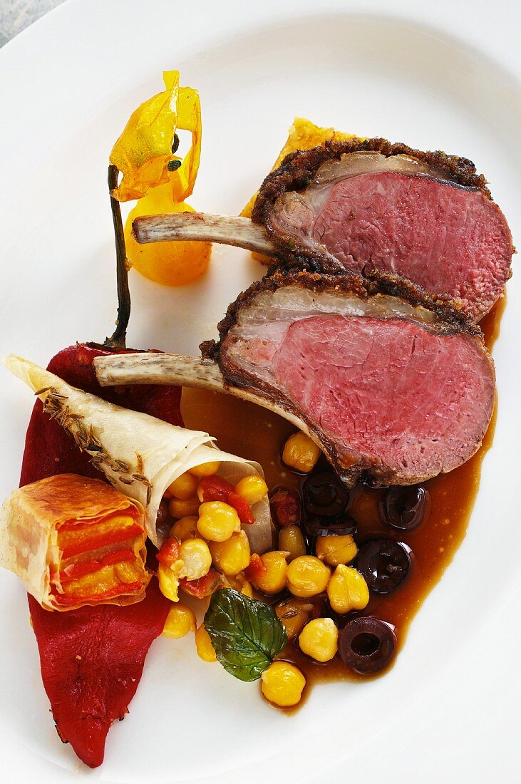 Saddle of lamb with an olive crust, chickpeas and a pepper medley