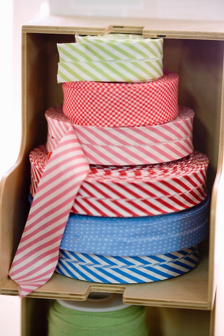 Rolls of fabric trim in wooden shelf compartment