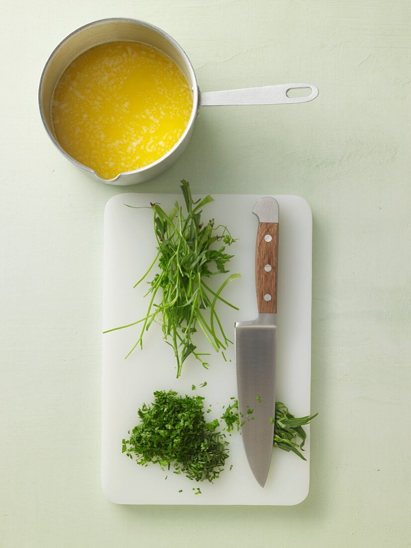 Herbs being chopped and butter being boiled
