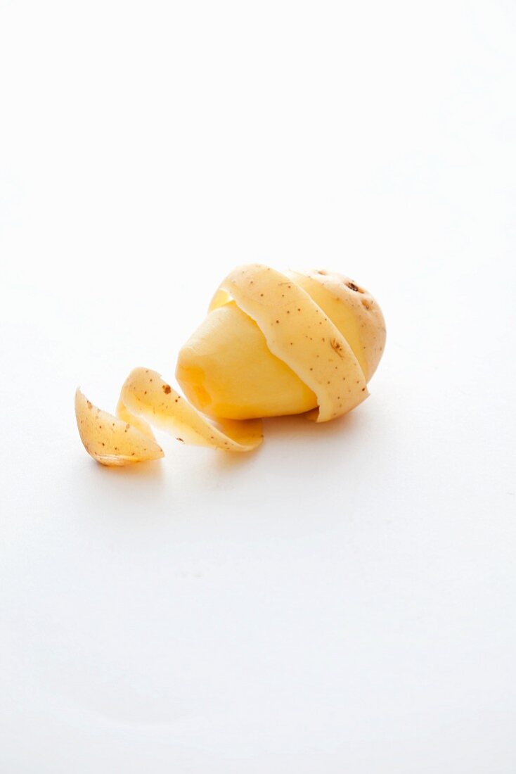 A potato, partially peeled