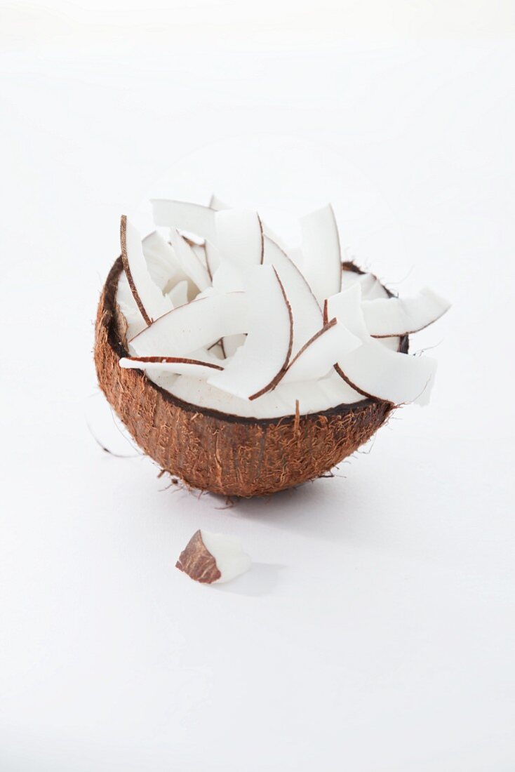 Kokosnusshälfte mit Kokoschips gefüllt