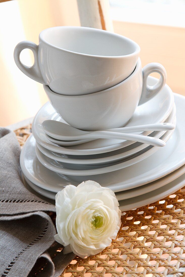 weiße Kaffeetassen mit Untertassen und Kuchentellern