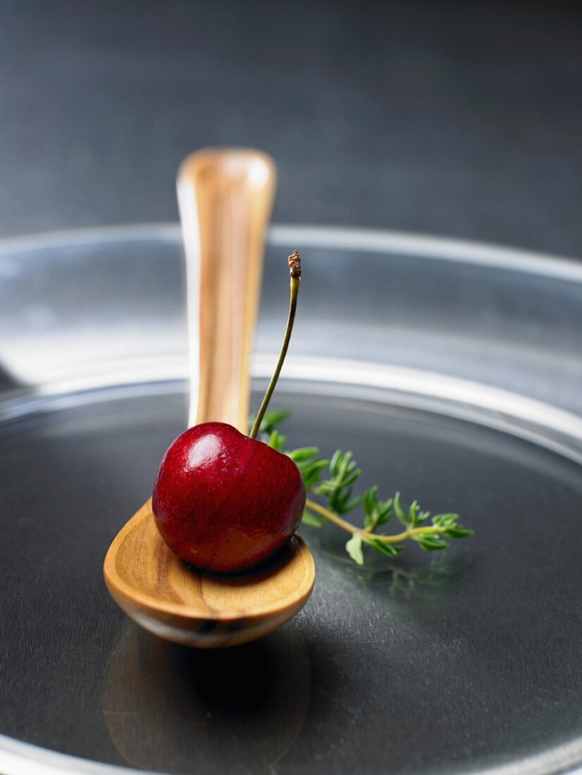 A cherry on a wooden spoon