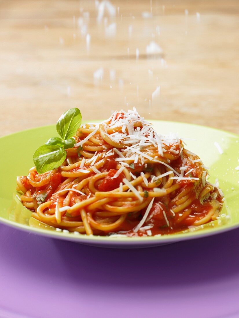 Spaghetti mit Tomatensauce werden mit Parmesan bestreut