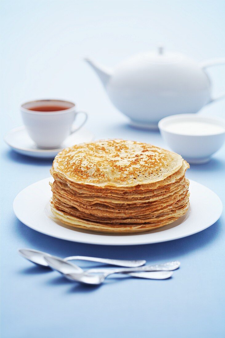 Gestapelte Pfannkuchen, Sauerrahm und Tee