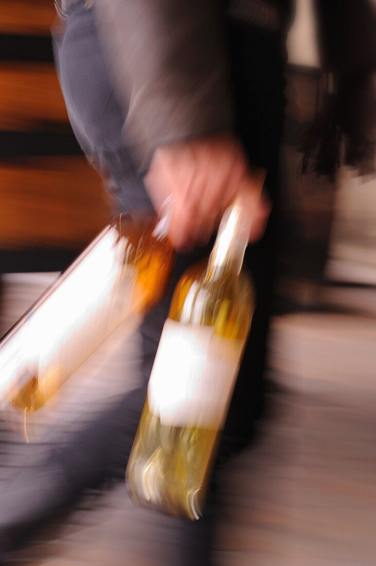 A person carrying two bottles (Cognac, Pineau)