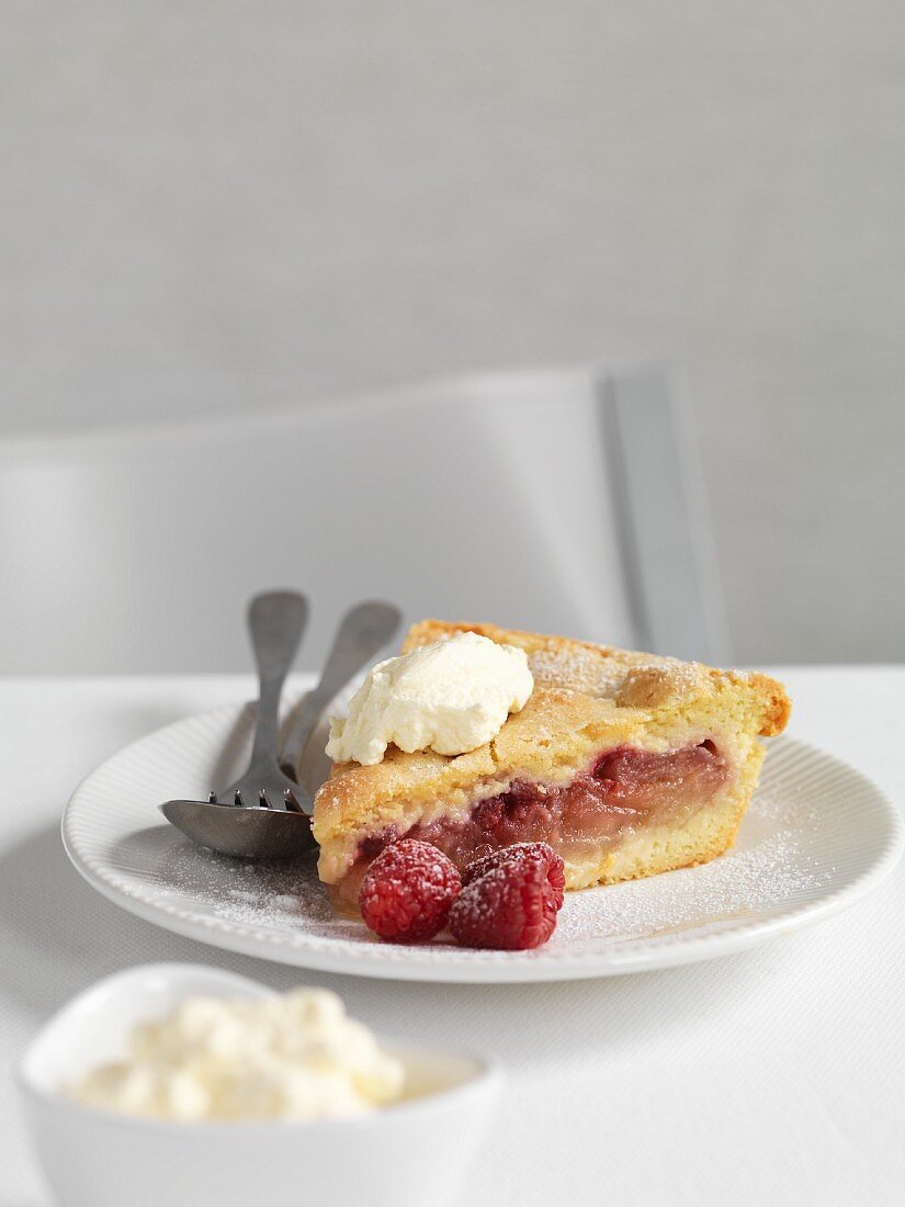 A slice of raspberry and apple shortcake with cream
