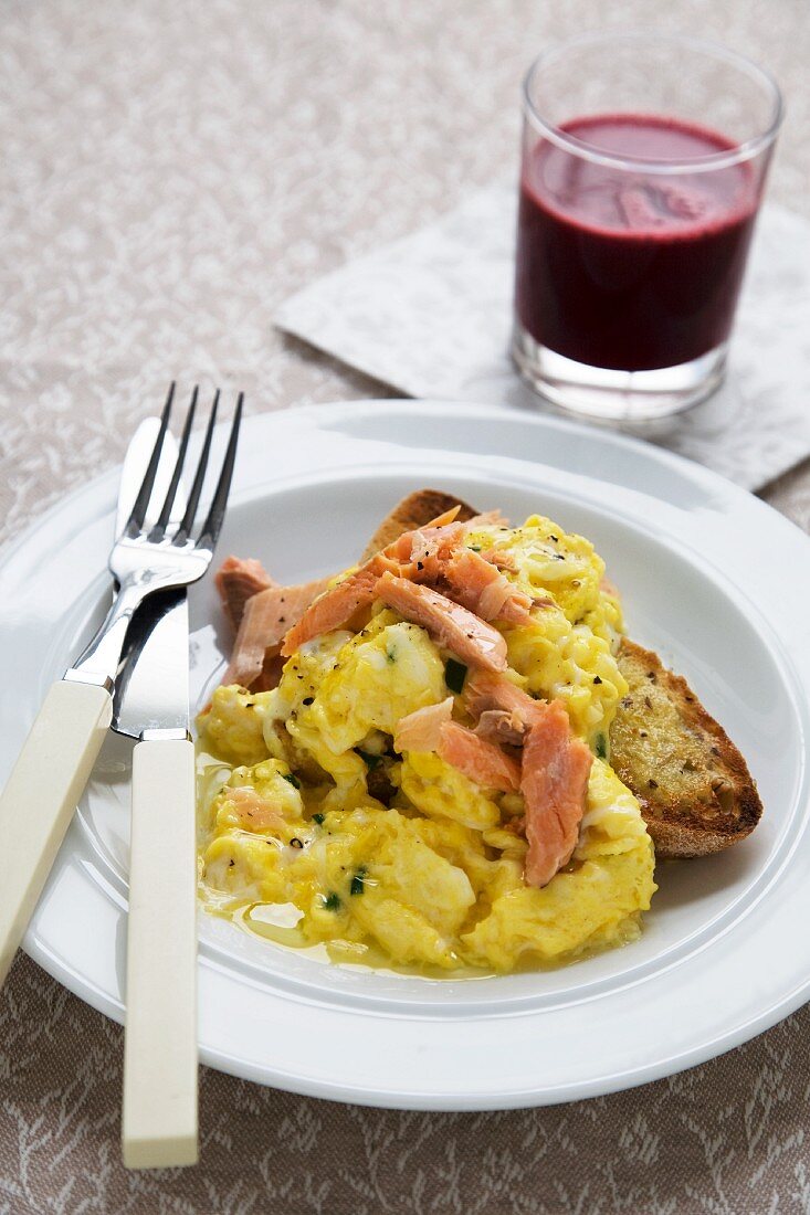 Breakfast Plate of Scrambled Egg and Smoked Trout Over Toast; Glass of Beet Juice