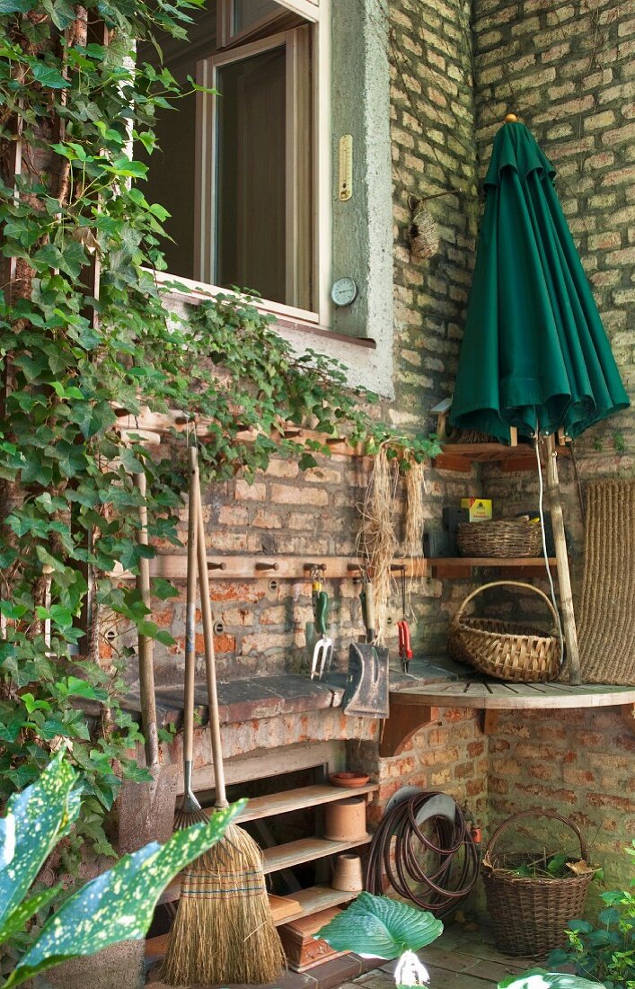 Storage rack in outside corner next to open window in brick facade