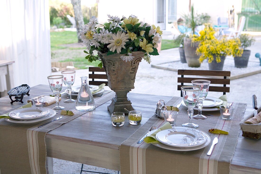 Festively set table on terrace with view of courtyard