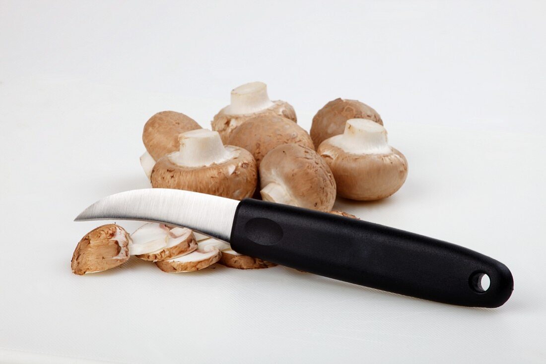 Brown mushrooms with a knife