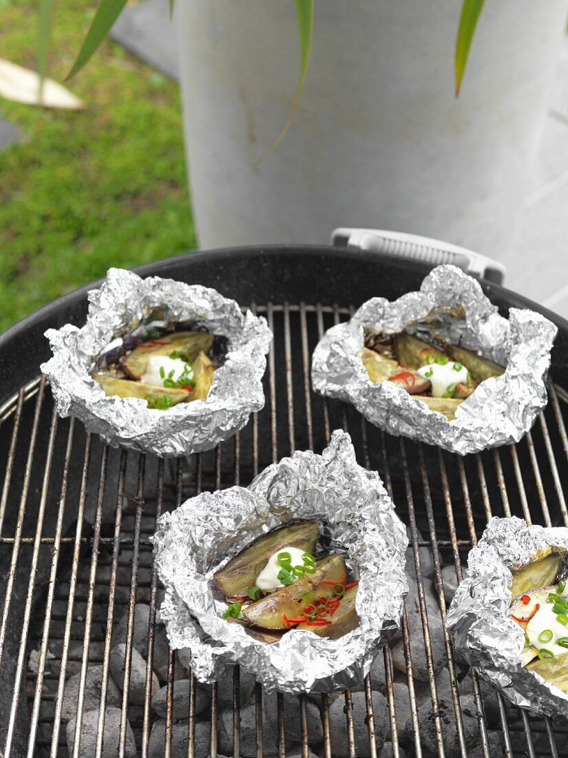 Sweet potatoes wrapped in foil on a barbecue