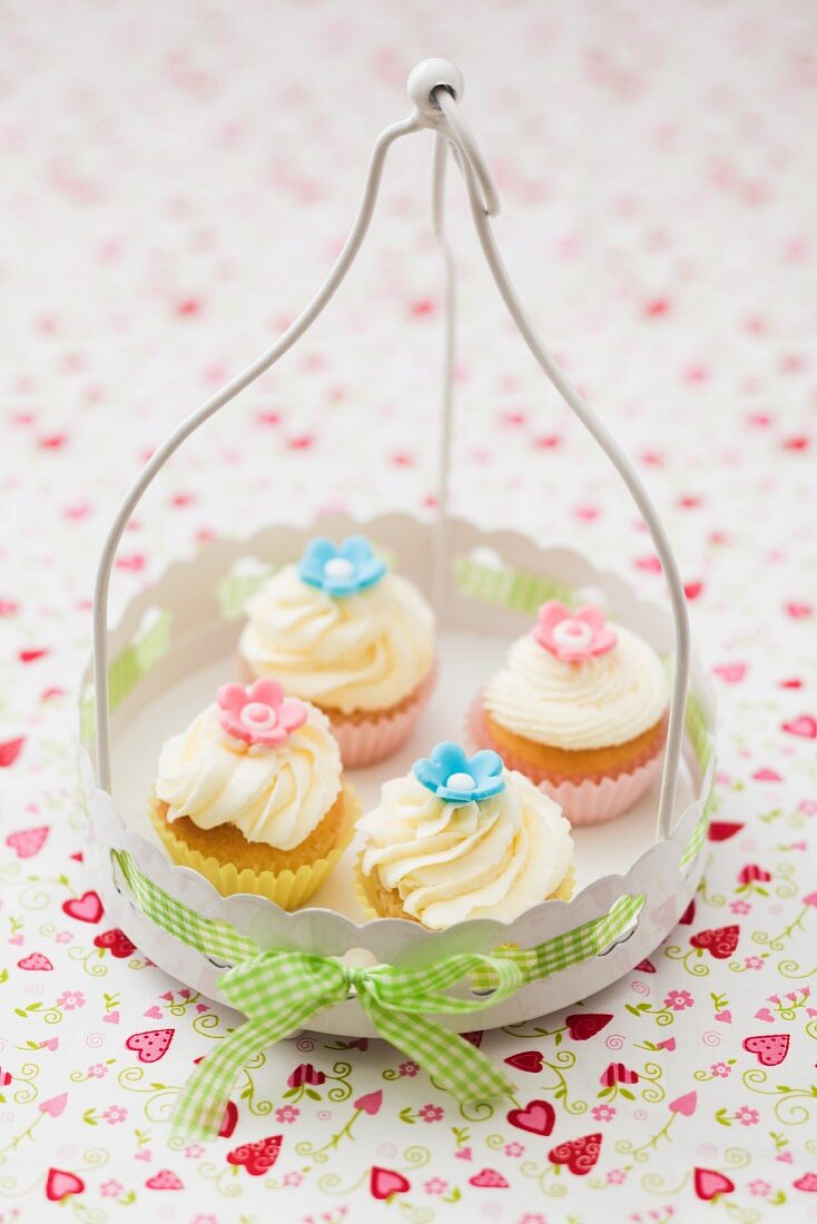 Four cupcakes in a white metal basket