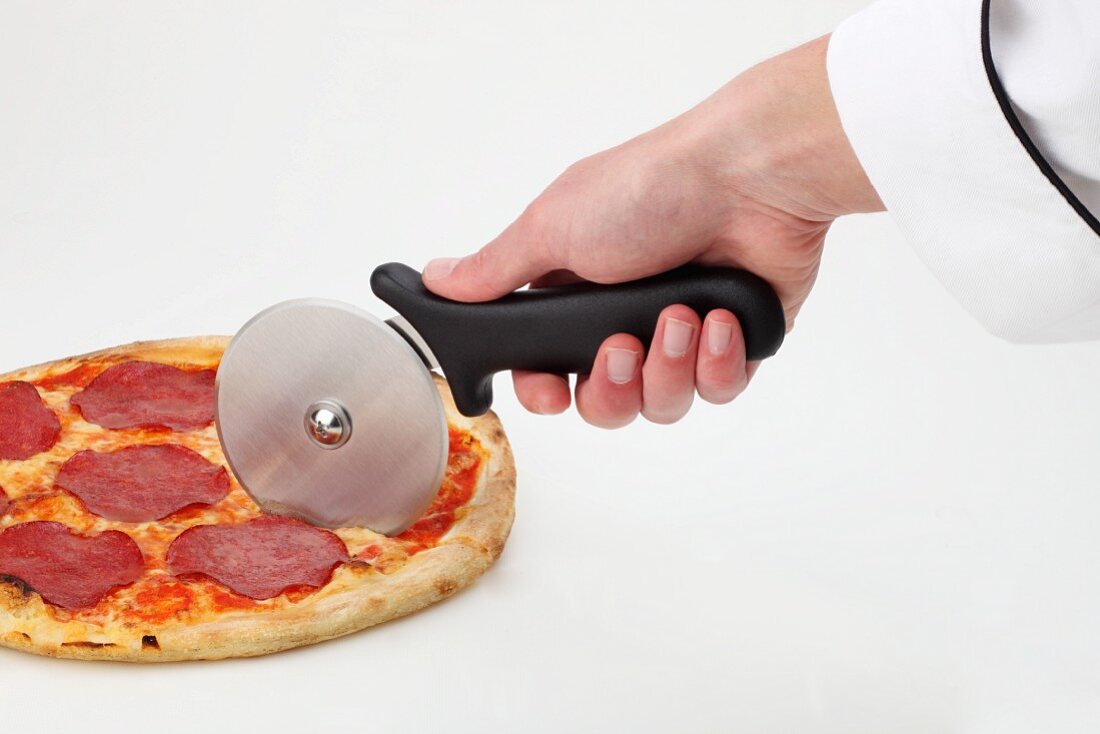 A pizza being cut