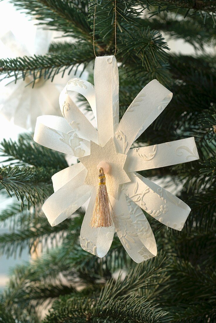 Selbst gebastelter Papierstern als Weihnachtsbaumanhänger