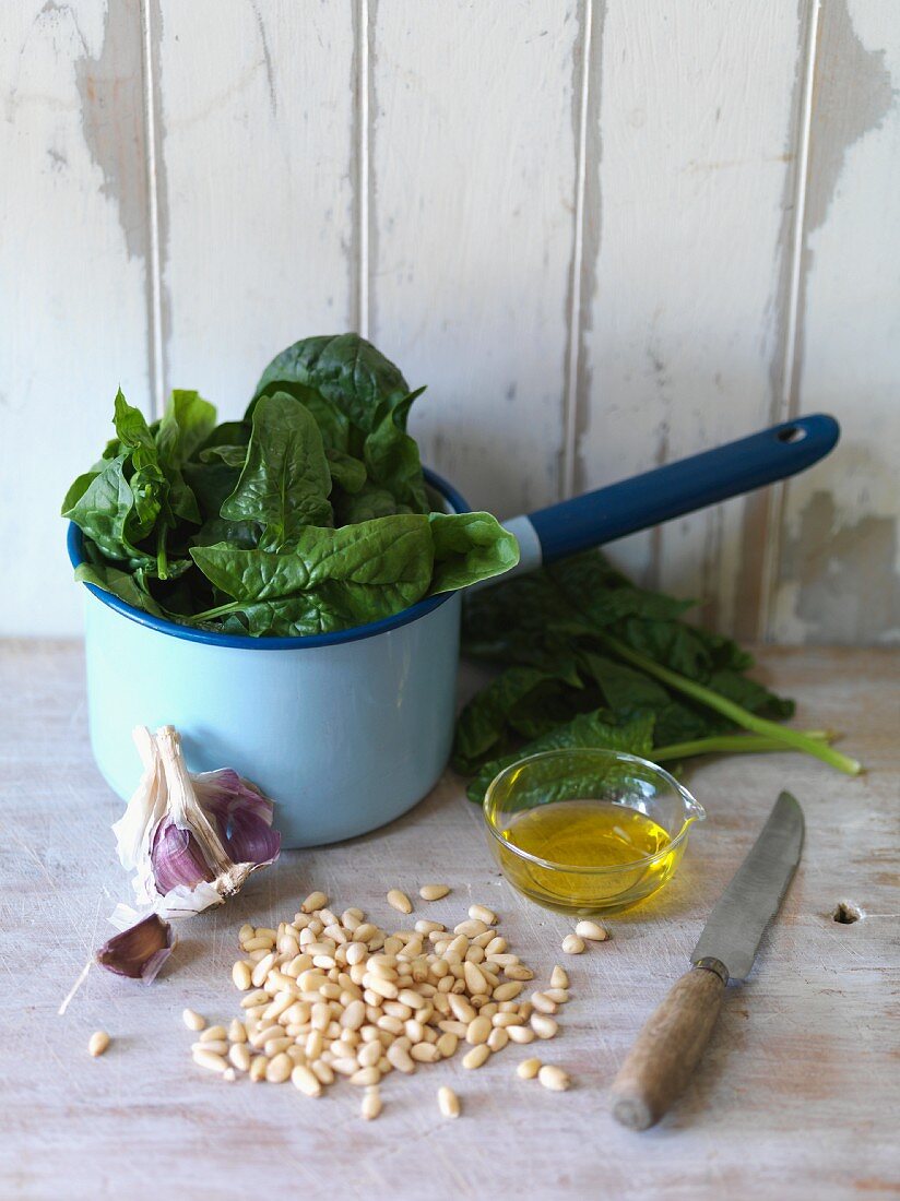 An arrangement of spinach, pine nuts, garlic and oil