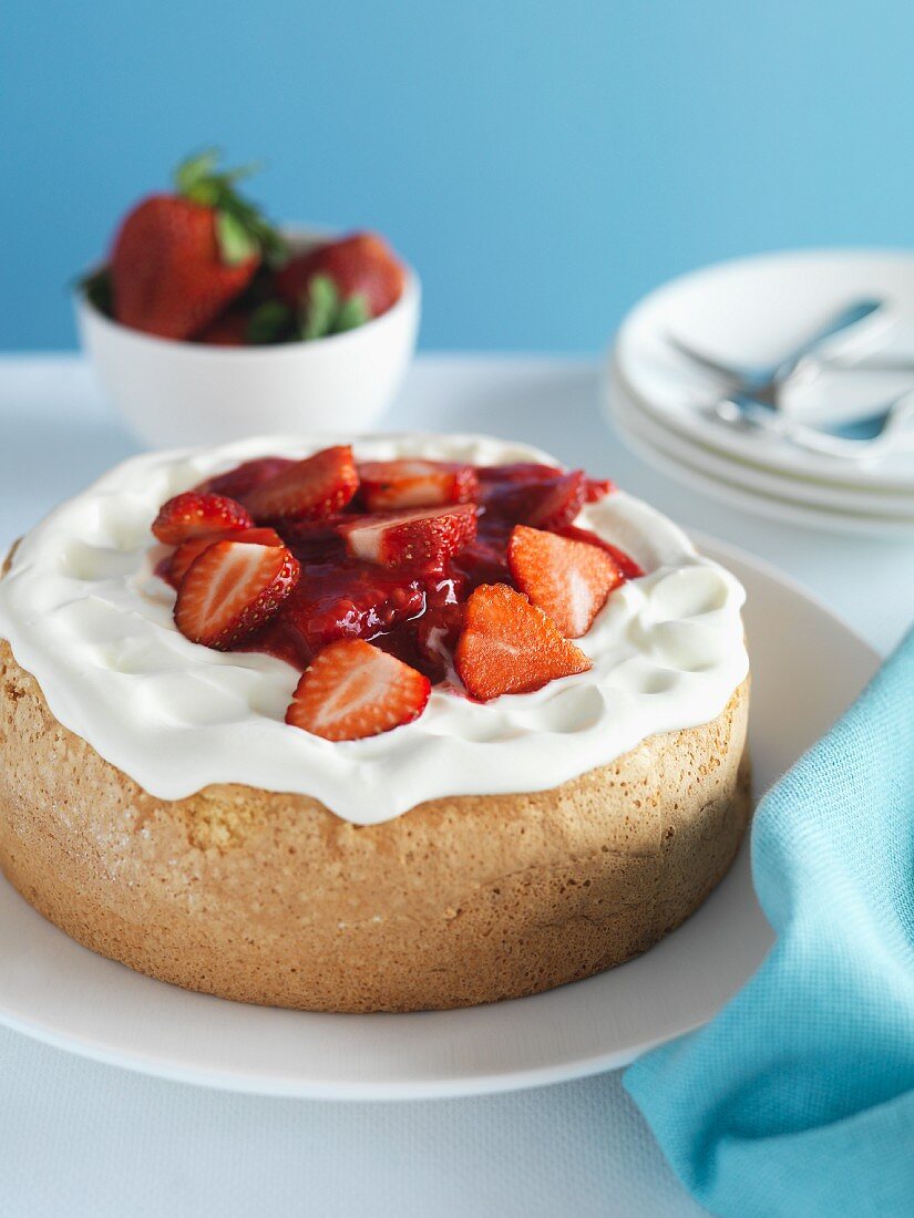 Mini sponge cakes topped with cream and strawberries