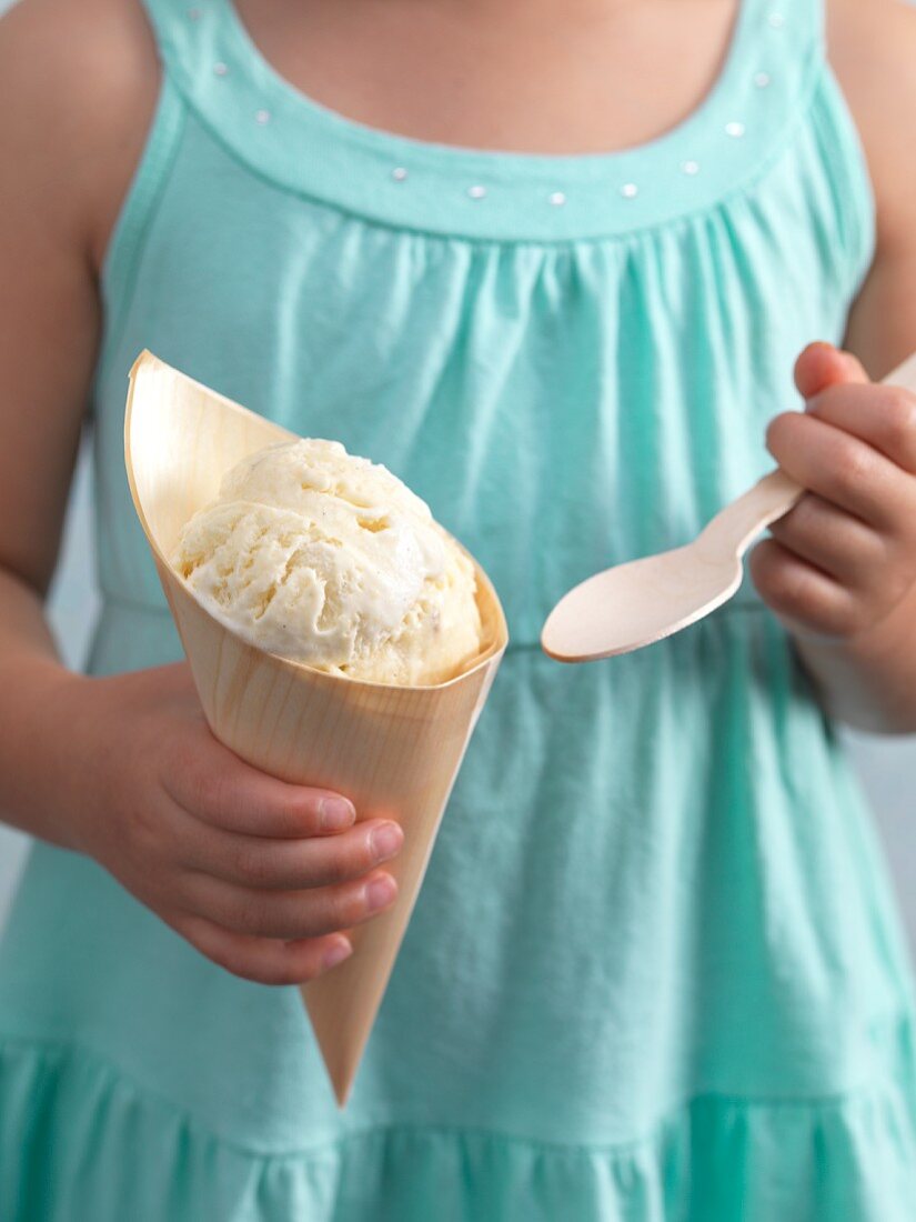 A girl holding a cone of banana ice cream