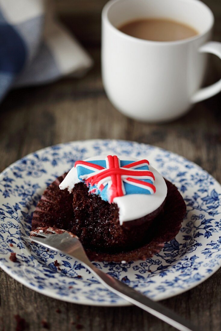 A Union Jack cupcake with a bite take out (Great Britain)