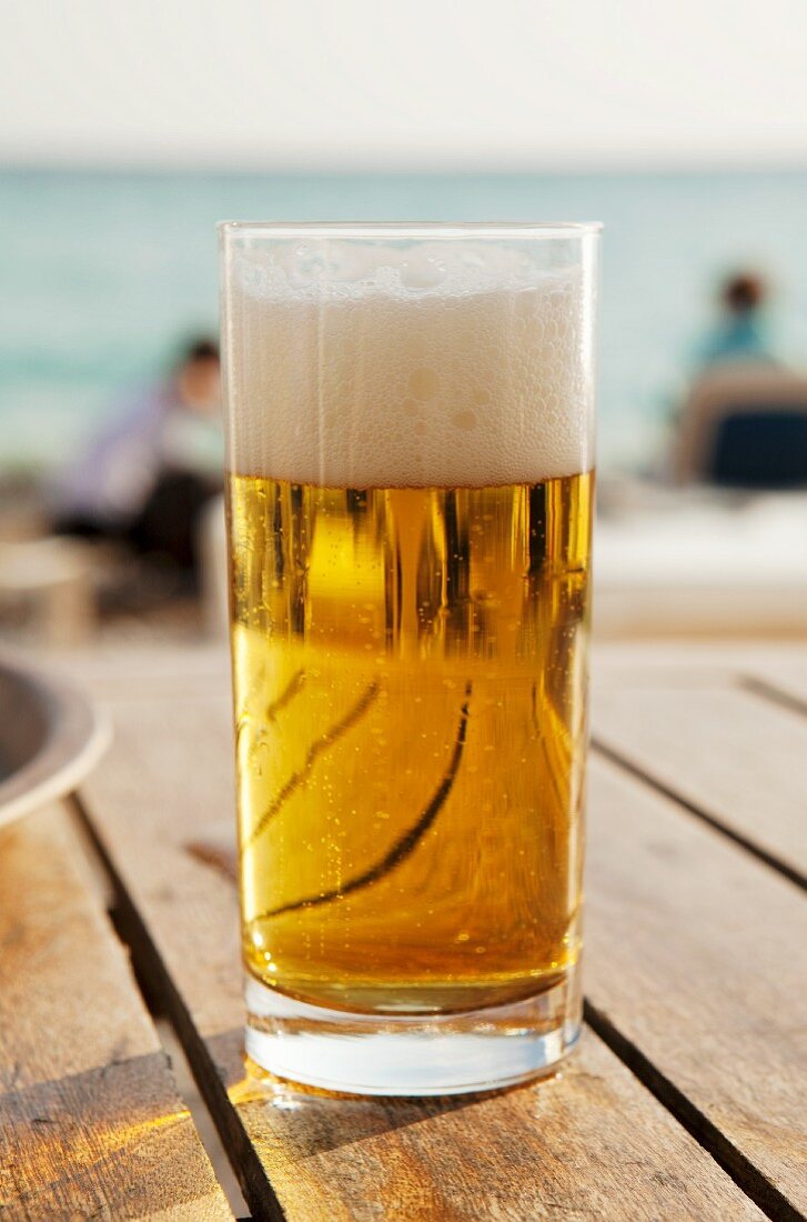 Ein Glas Bier auf eine Tisch im Freien