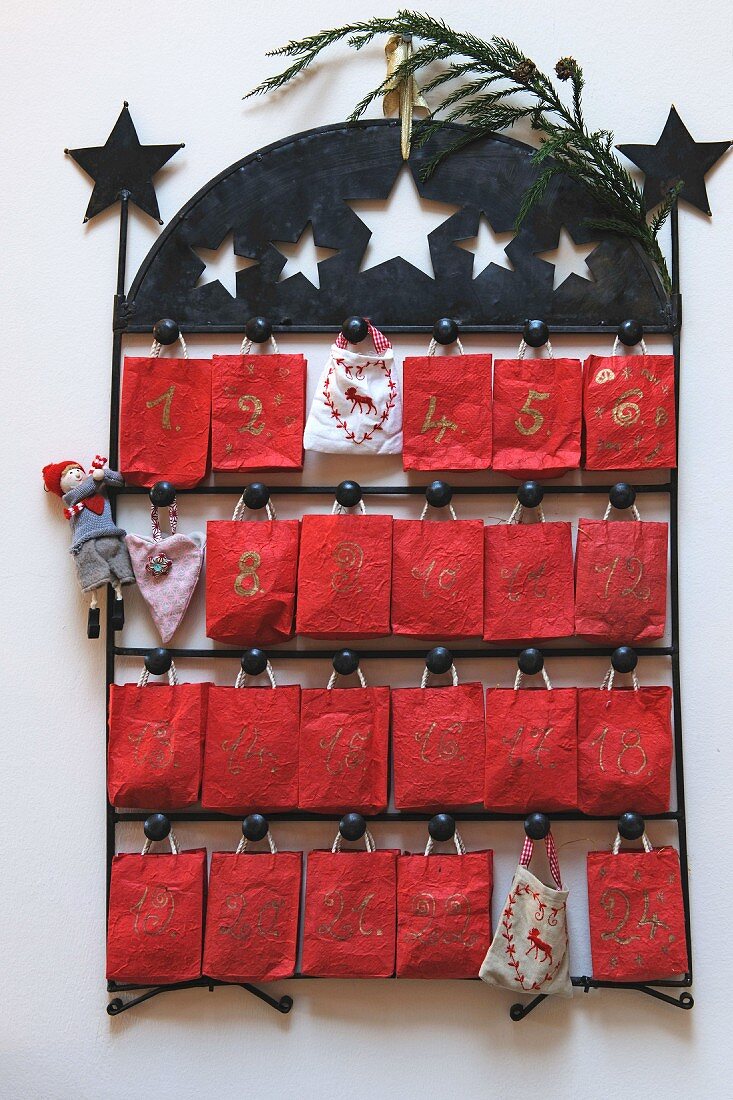 Advent calendar - little red sacks hanging on black metal frame