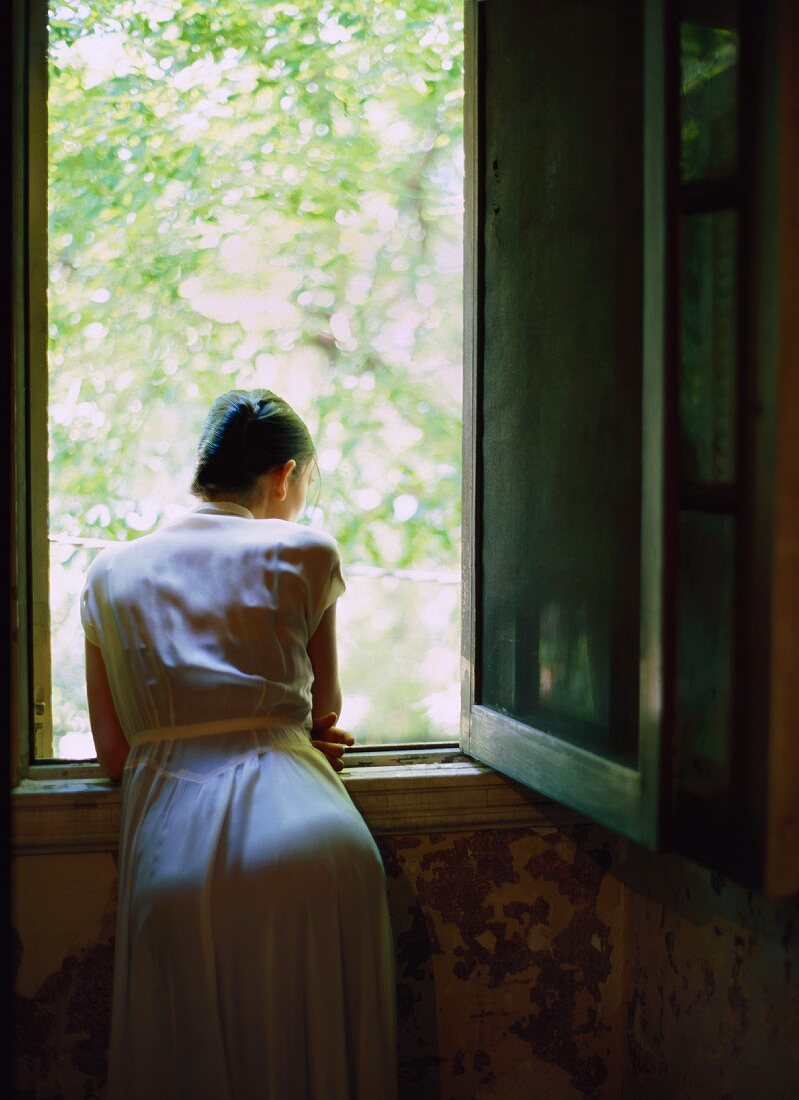 A young woman looking out of the window