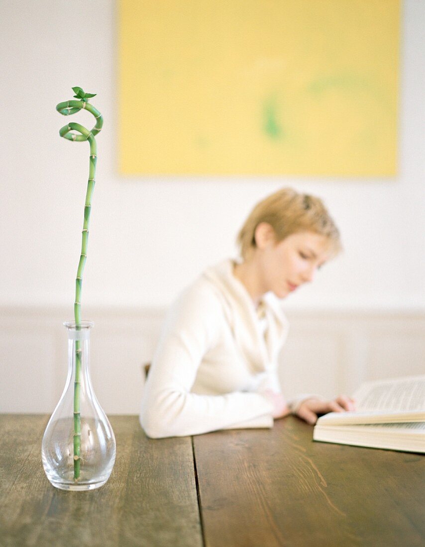 A young woman reading a book at a table