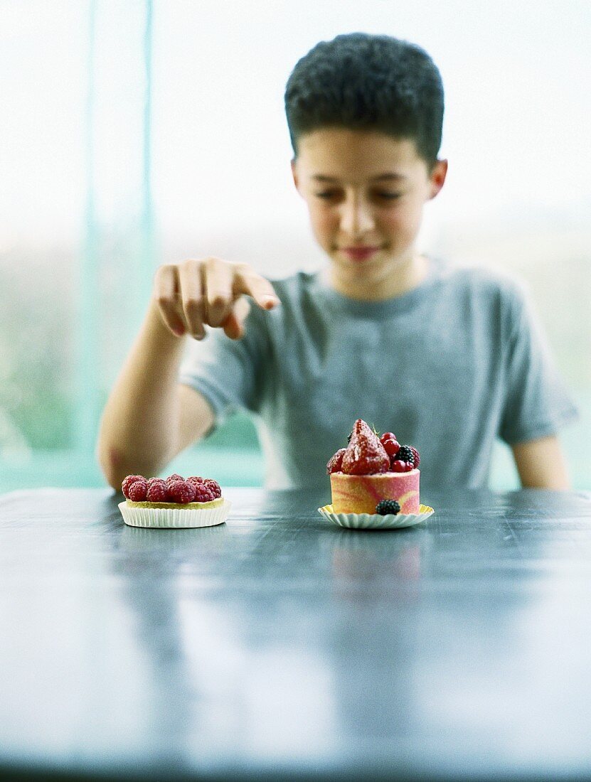 A boy sitting at a table with a tartlet