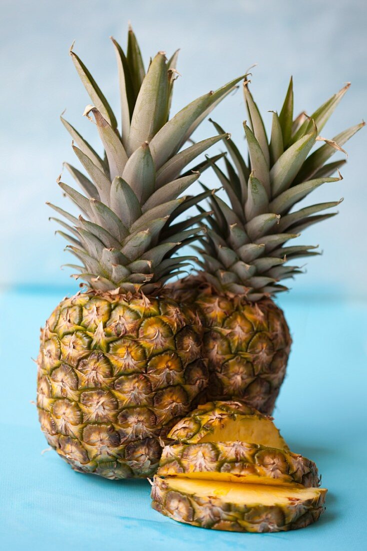 A whole pineapple and pineapple slices