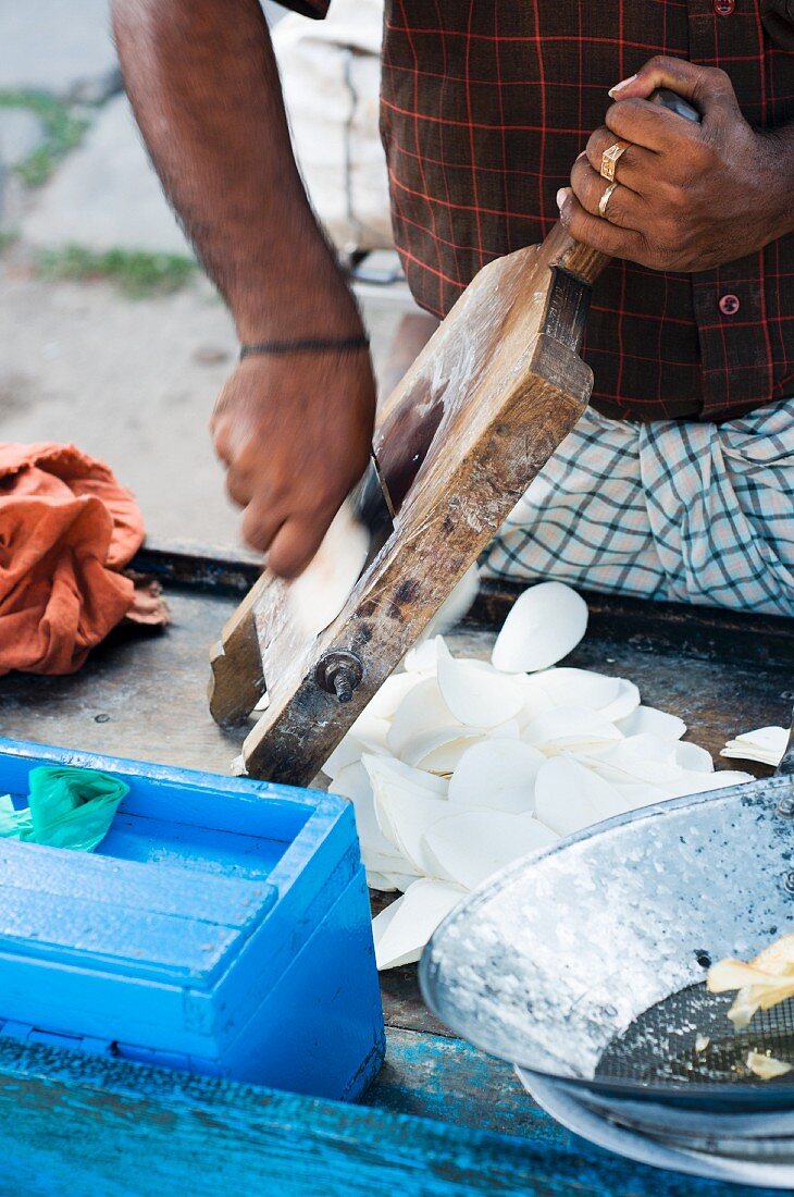 Indischer Strassenhändler bereitet Kartoffelchips zu