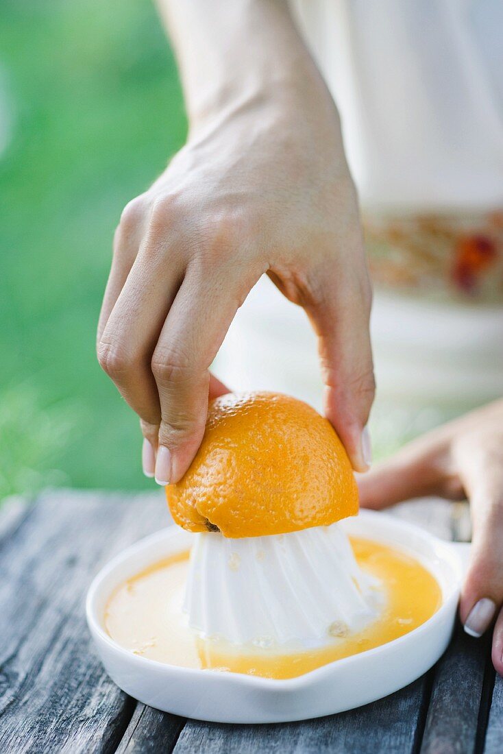 Frau presst eine Orange aus